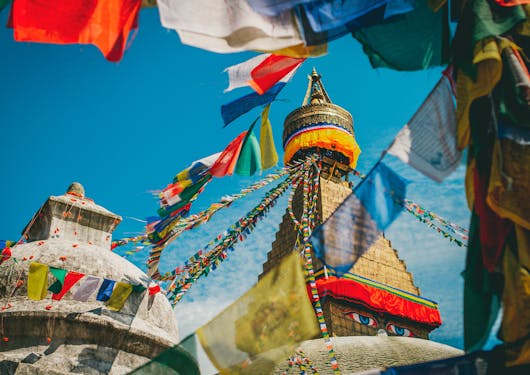 Colorful prayer flags drape over the top of temples in Nepal.