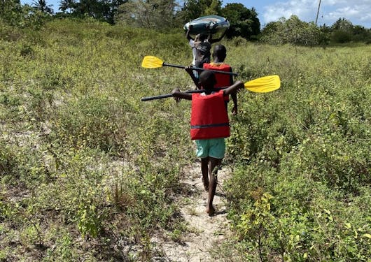 Kids with paddles head toward Mida Creek in Kenya.