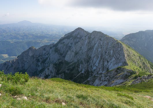 Romania's Carpathian Mountains are shown, with a prominent boulder emerging from the hill side and forming small peaks.