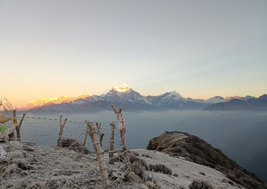 Sunrise creeps over mountain peaks as seen from the Khopra Ridge Trek in Nepal.