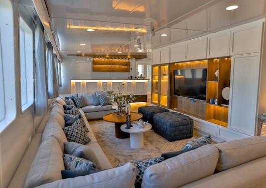 The lounge area with a comfortable couch and cozy pillows is shown on the luxury yacht used for the Galapagos Citizen Science scuba diving trip.