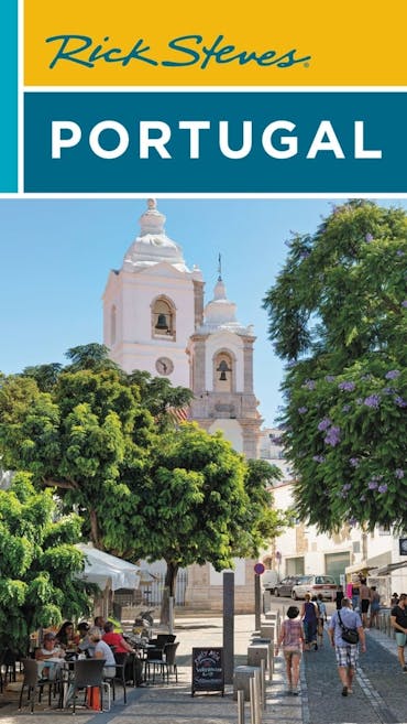 The cover image is shown of Rick Steves' book about Portugal, with a bright sunny image showing trees and a white church.
