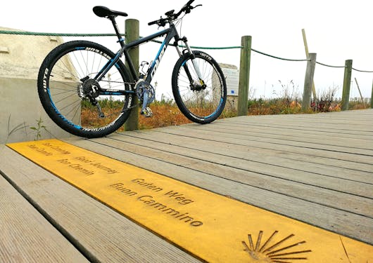 A bike rests on a wooden boardwalk along the Camino de Santiago in Portugal.