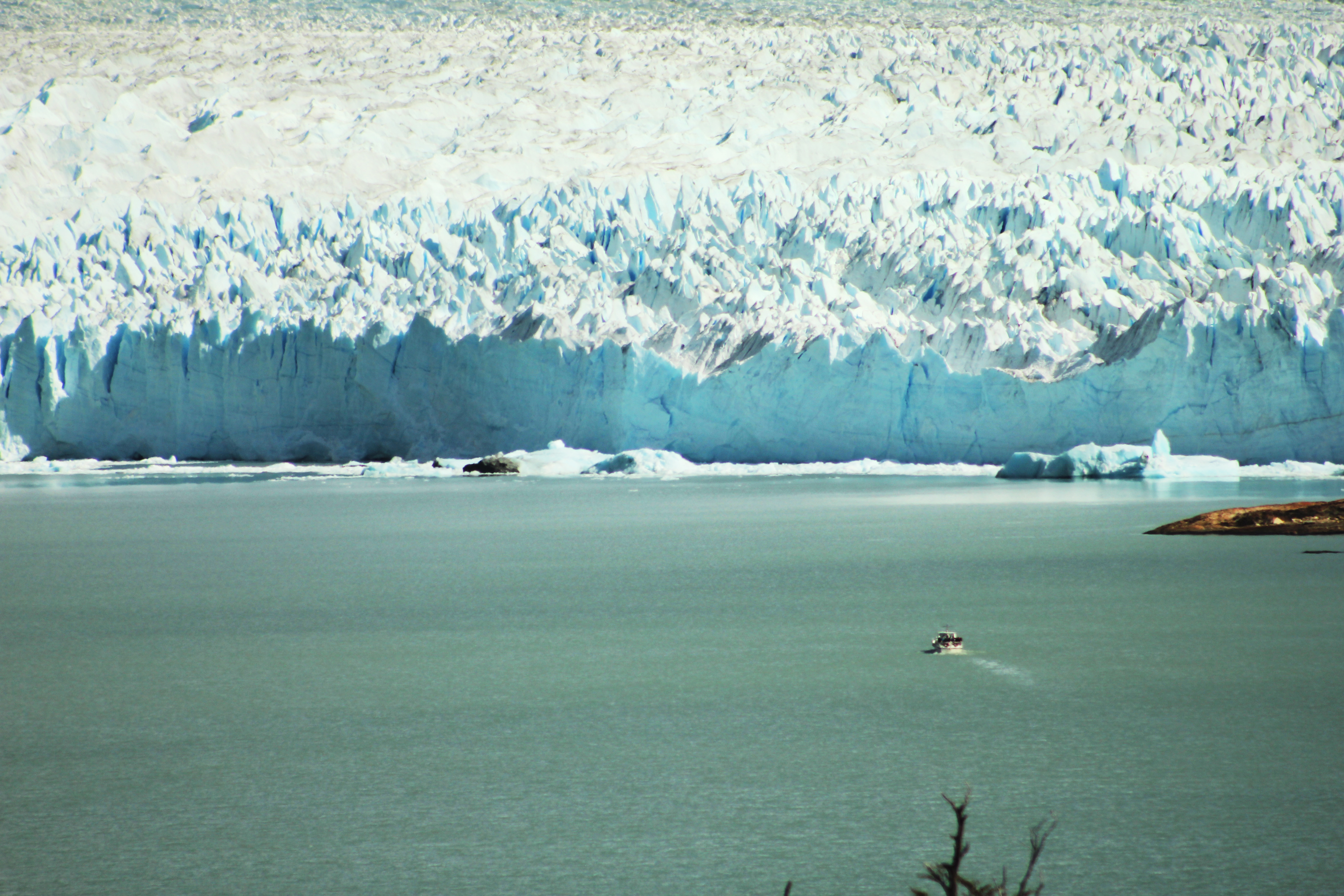 The Perito Moreno Glacier in El Calafate, Argentina, is shown, with its icy white sheet ending in a frigid glacial lake.
