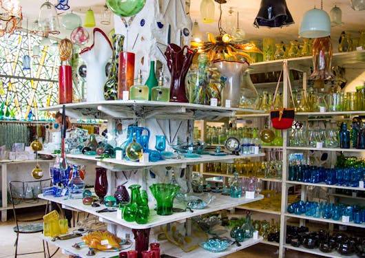 A local souvenir shop with colorful glass products is shown in Kenya.