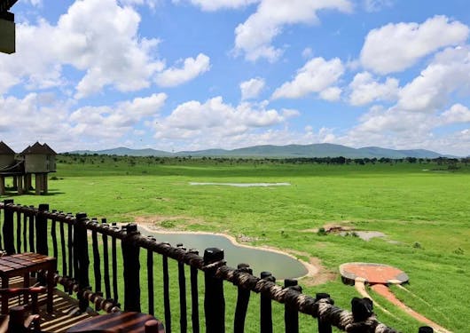 The view of green plains as seen from the deck of a lodge in Kenya on a sunny and cloudy day.
