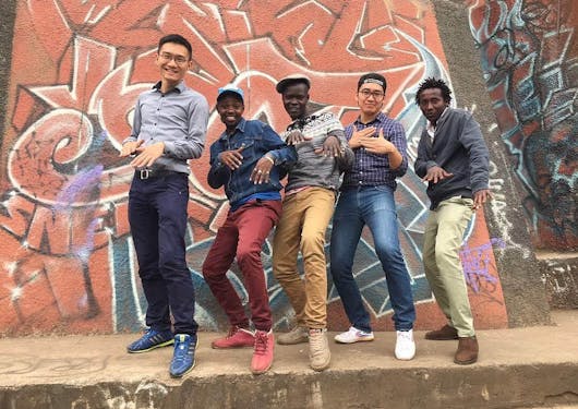Two travelers with three local men from Nairobi on a street walking tour.