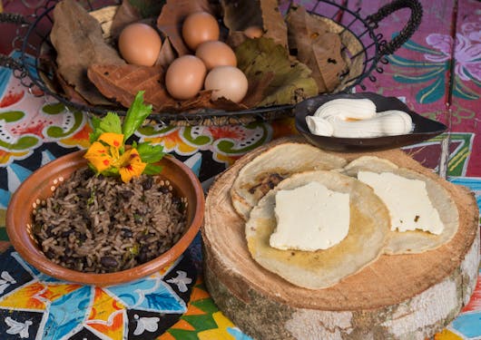 A traditional meal of rice and bread with cheese is served on a colorful table cloth in Costa Rica.