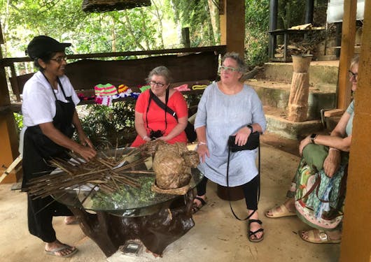 A woman empowerment session brings togeether a few Caucasian women with a local Sri Lankan artisan woman who is making reed baskets.