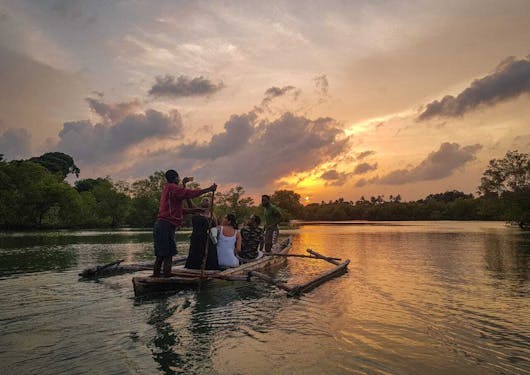 A sunset canoe ride shows several people being gently paddled around a lake in Kenya.