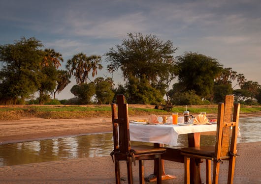 A romantic breakfast for two at sunrise is set up in Kenya.
