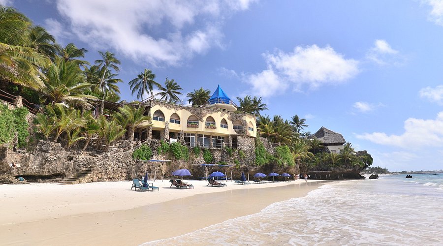 A perched beachfront hotel is shown from the water in Kenya.