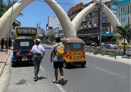 Four tusks forming two arches over a wide street in Mombasa City are shown.