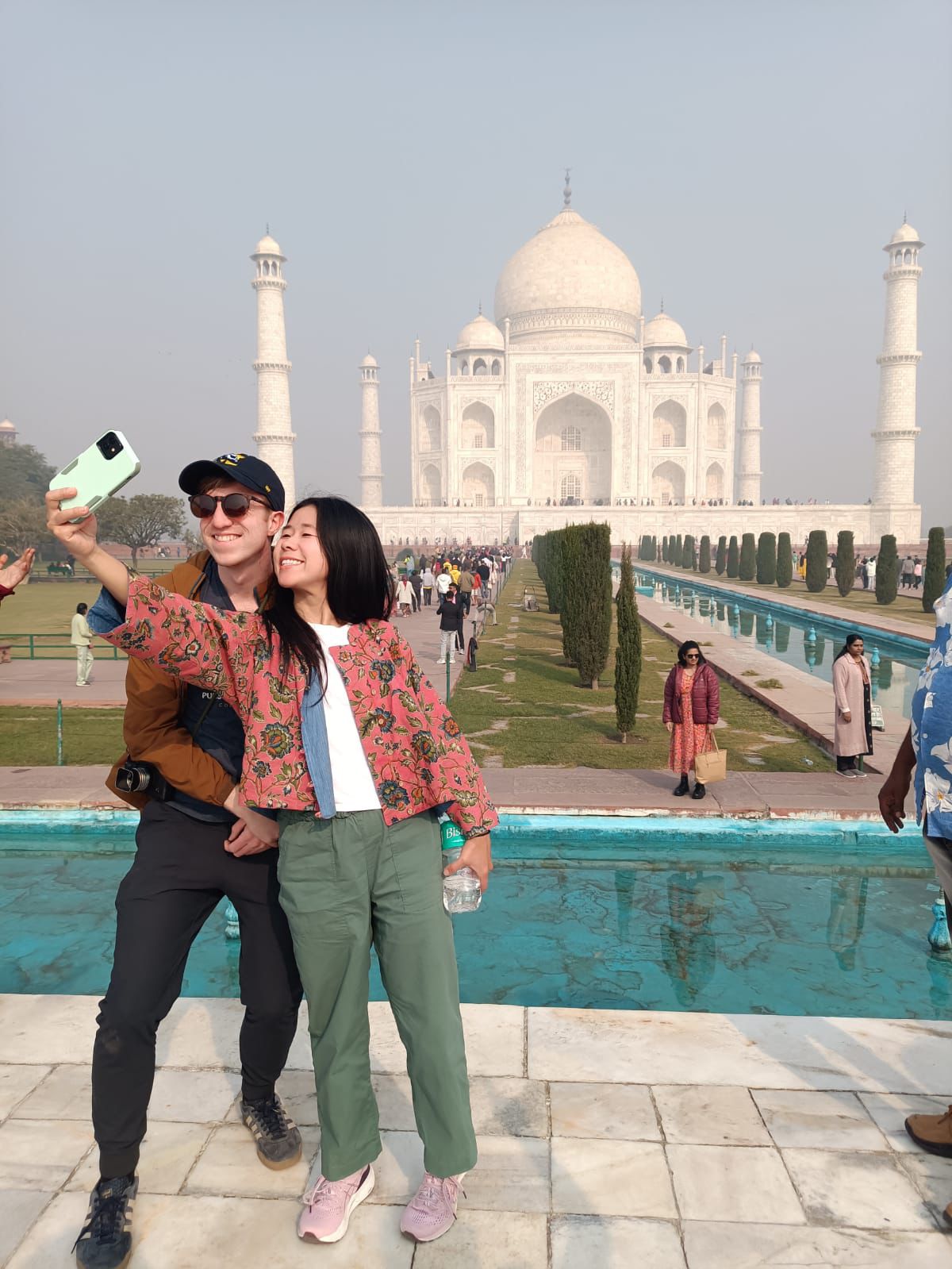 A couple poses and takes a selfie in front of the Taj Mahal in Agra, India.