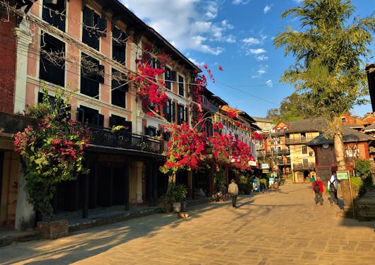 The town of Bandipur at golden hour, with bright red flowers hanging from the buildings.