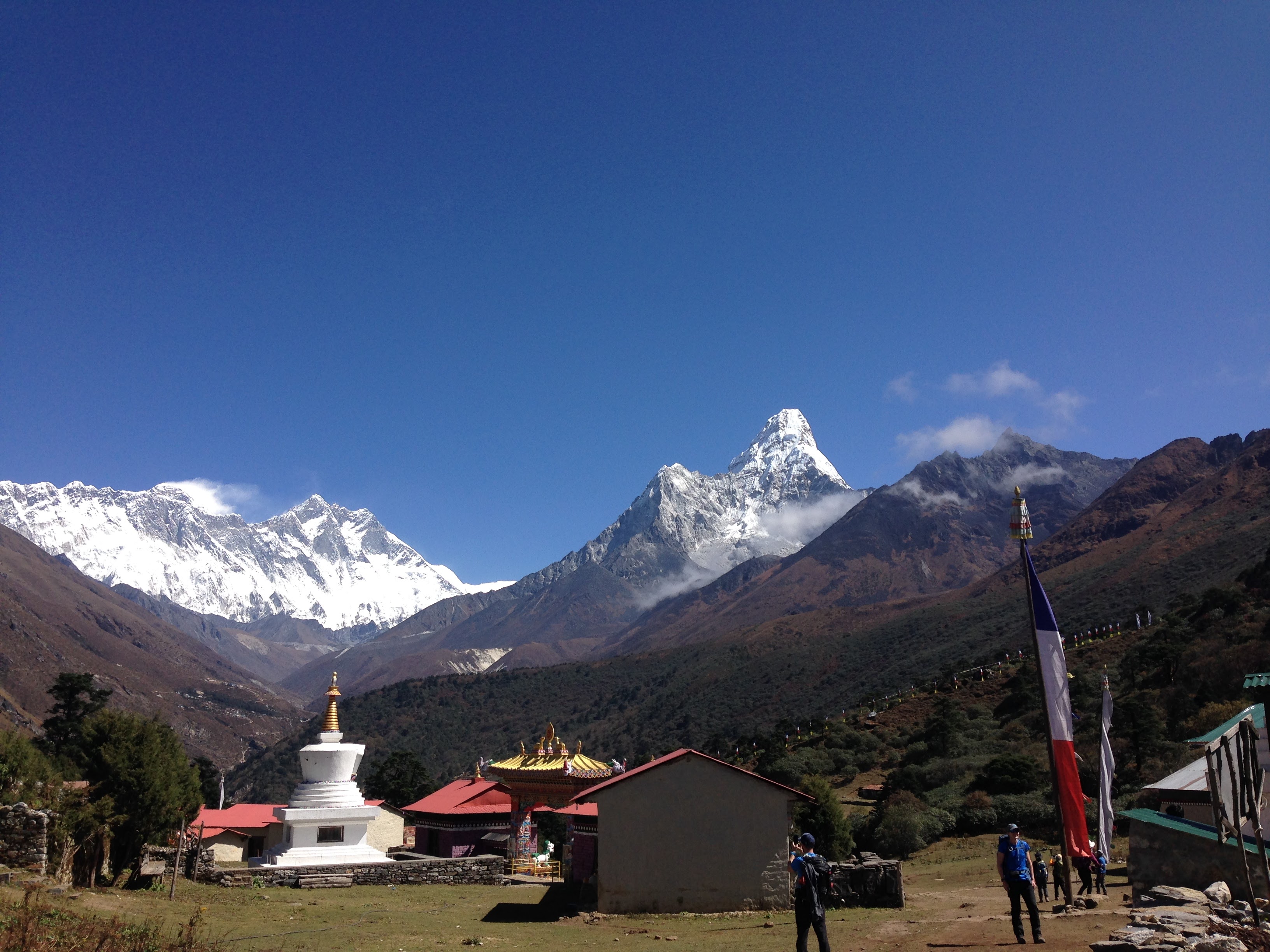 A camp along the Everest Base Camp trek with a few buildings and mountain peaks in the background.