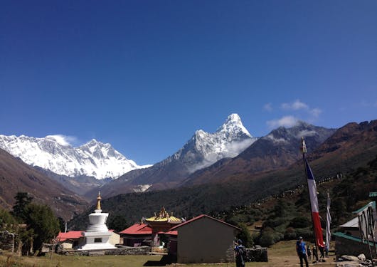 A camp along the Everest Base Camp trek with a few buildings and mountain peaks in the background.