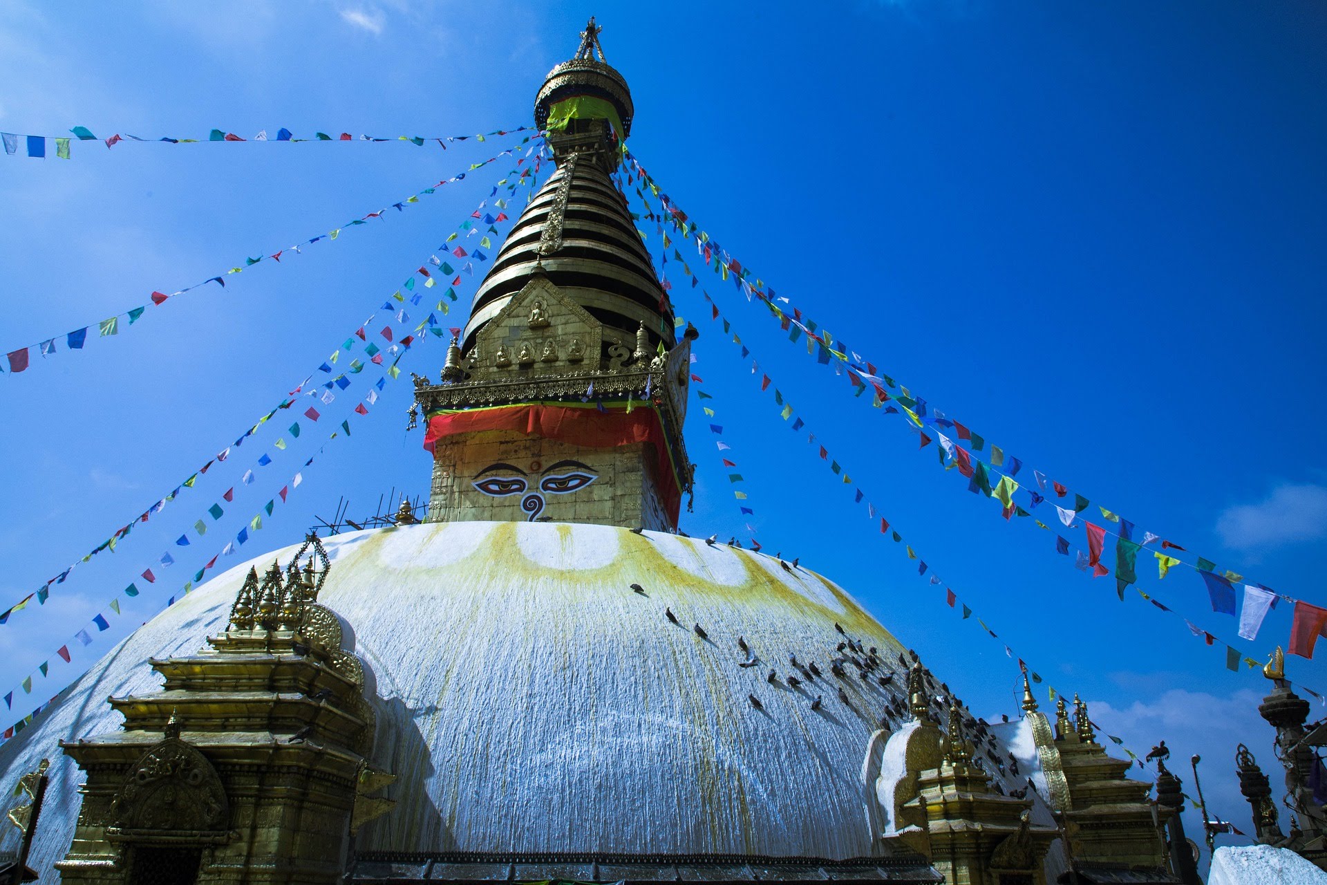 Prayer flags hang from the top of the Swayambhunath temple, spanning outward in many directions.
