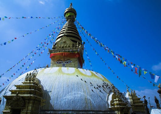 Prayer flags hang from the top of the Swayambhunath temple, spanning outward in many directions.