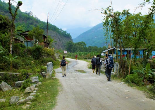 Travelers are shown walking along the path to Birethathi in Nepal on the Annapurna Panorama Trek.