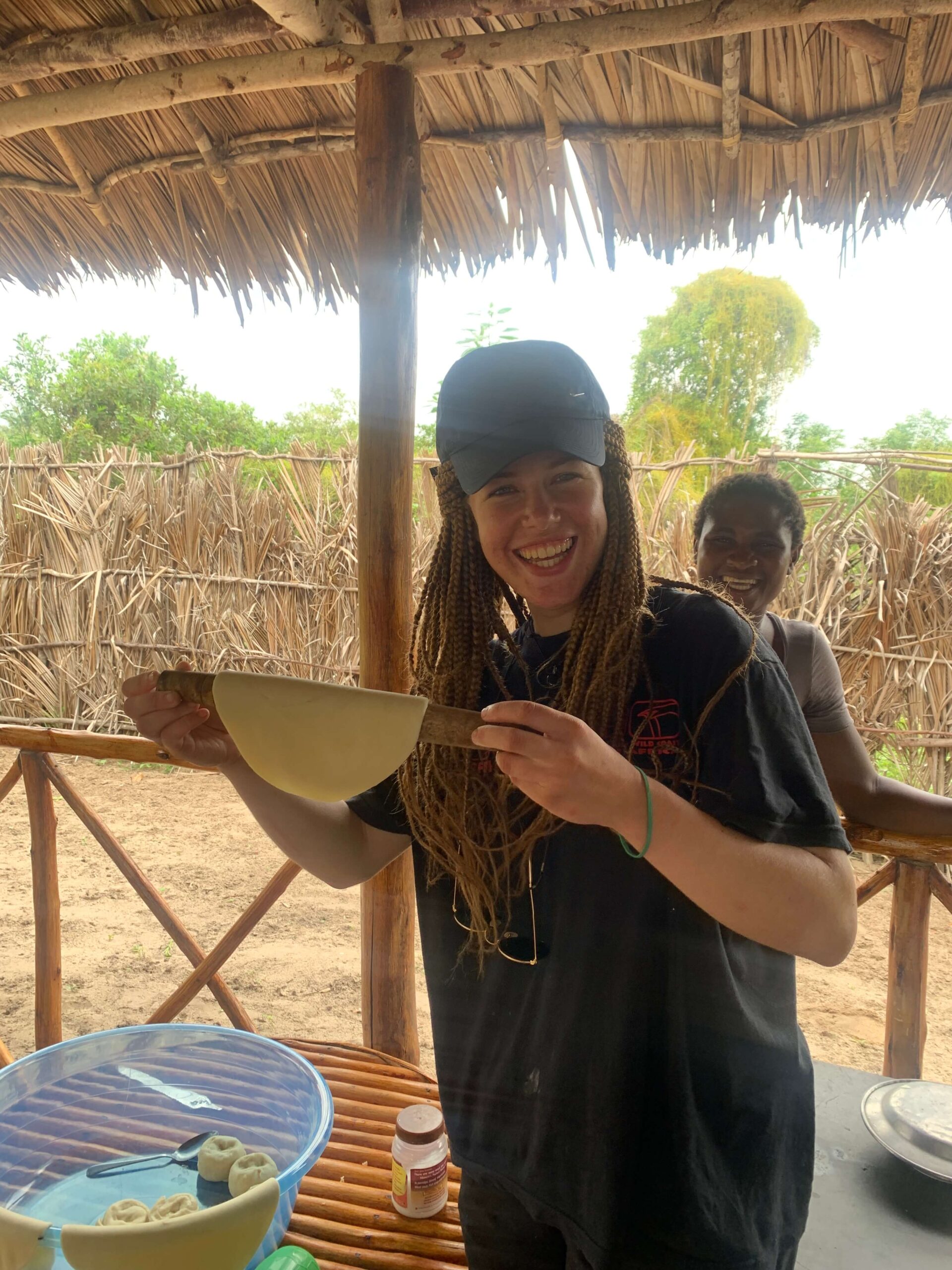 An adult female traveler holds up a dish while visiting the local Watamu Village in Kenya.