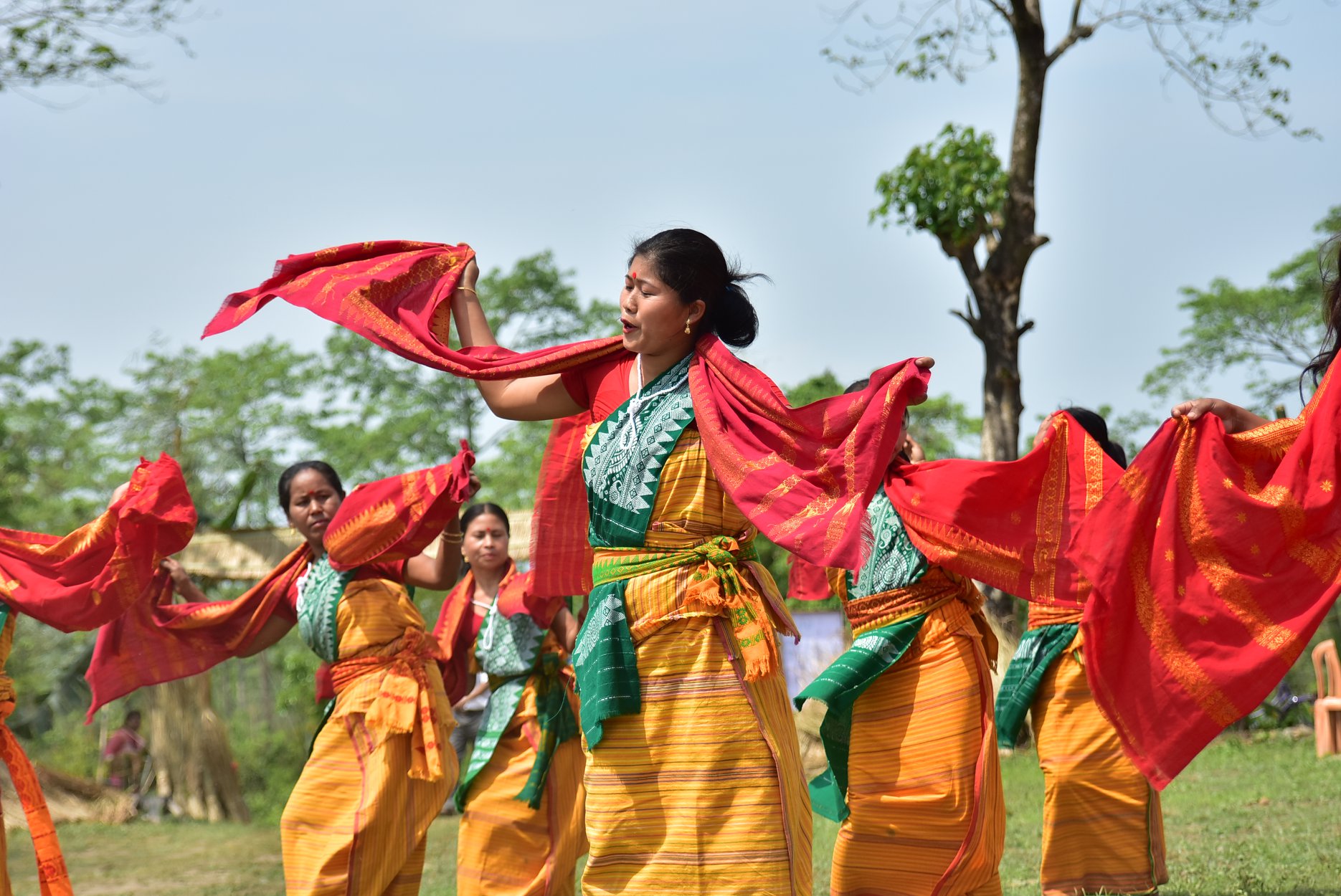 A group of women in India perform a traditional dance in colorful garb.