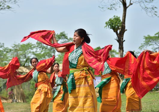 A group of women in India perform a traditional dance in colorful garb.