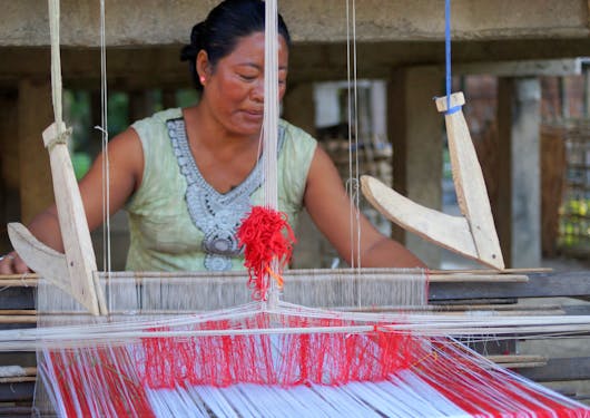 An Indian woman shows how a weaving mill works.