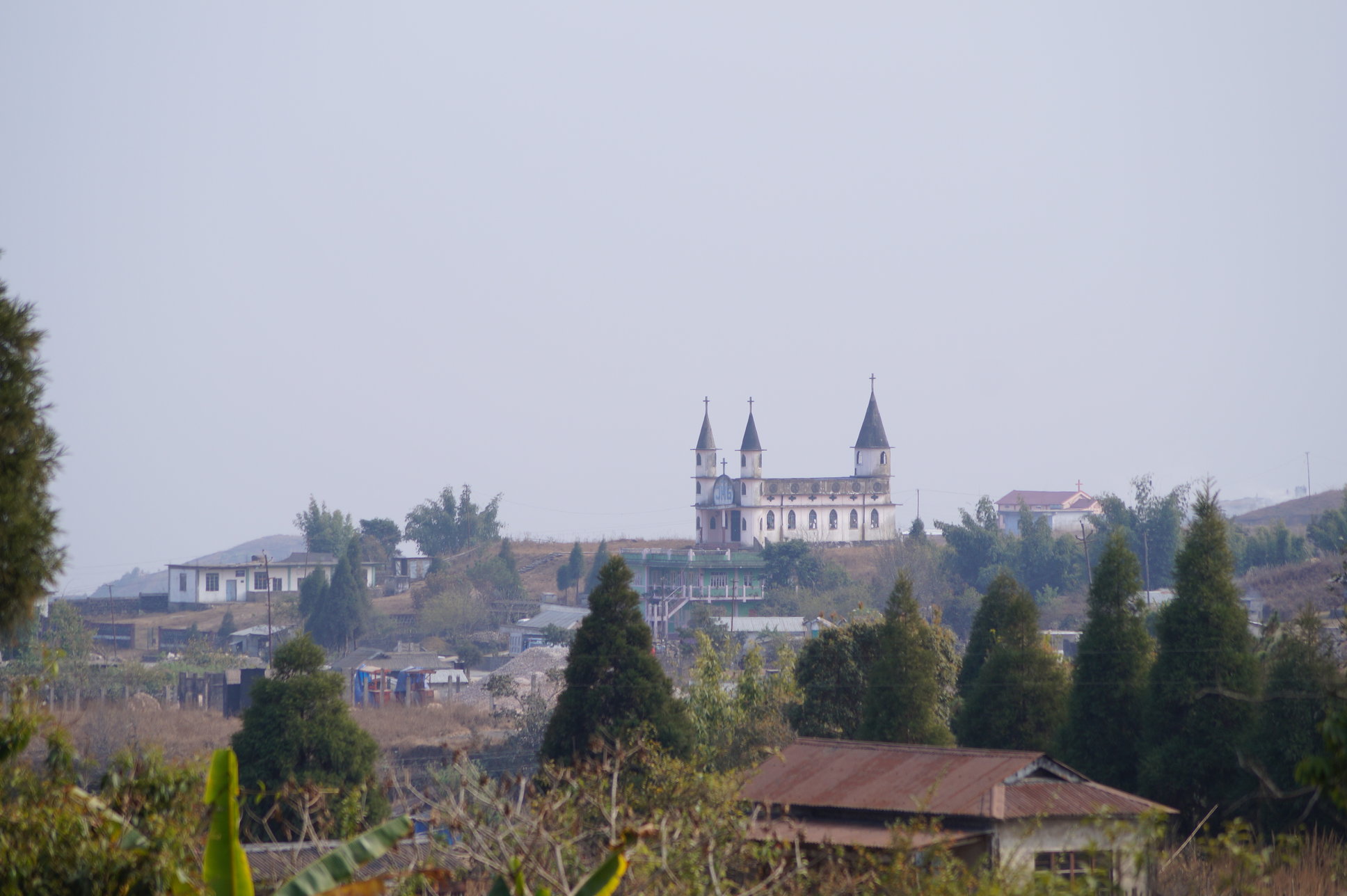 In India, the Cherrapunjee castle is in the distance under a grey sky.