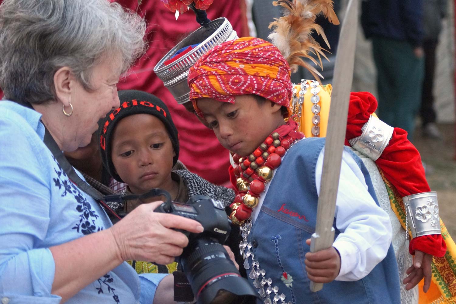 A tourist shows Indian children a photo at the Ka Shad Suk Mynsiem festival.