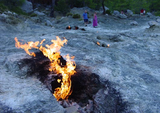 Fire shoots out of rocks, signifying the Chimera fire-breathing monster, on Mt. Olympos along the Lycian Way in Turkiye.