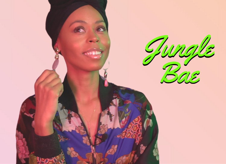 A headshot of a young Black woman with her hair in a wrap and wearing a patterned blounse and dangly earings, smiling at the camera in front of a pink background. The text "Jungle Bae" is in neon green to the right.