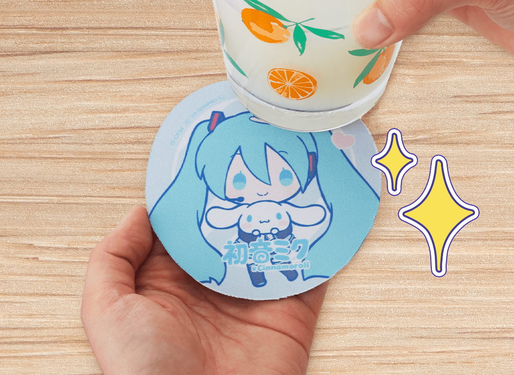 A picture of one hand holding a Hatsune Miku and Cinnamoroll coaster while the other hand holds a drink above it. 