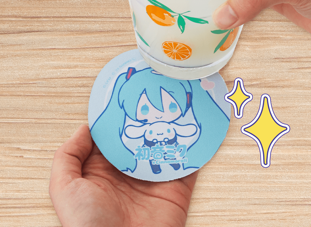A picture of one hand holding a Hatsune Miku and Cinnamoroll coaster while the other hand holds a drink above it.