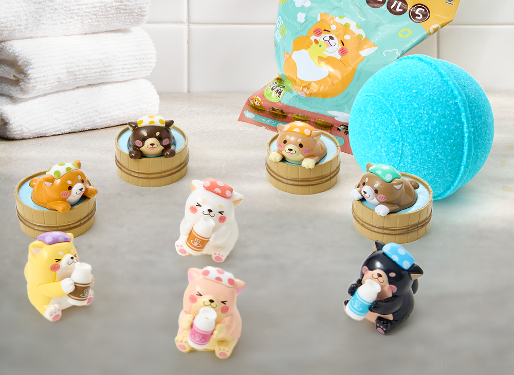 Shiba Inu bath toys in front of a blue bath bomb