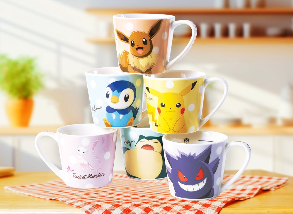 6 Pokemon mugs stacked on top of desk featuring Eevee, Pikachu Snorlax Piplup Mew and Gengar