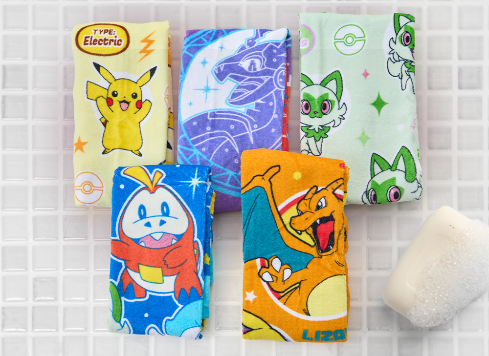 A varity of Pokemon towels sit on a bathroom counter.