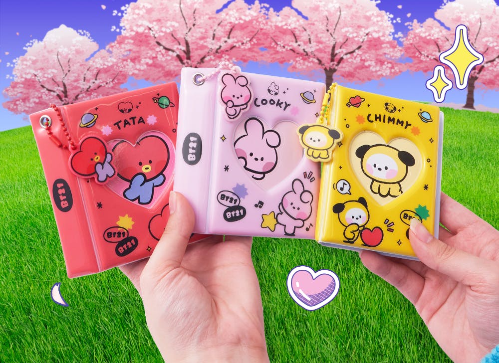 A picture of hands holding BT21 mini photo albums featuring Chimmy, Cooky, and Tata. 