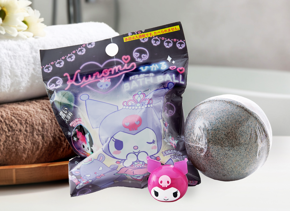 A kuromi bath bomb sitting on the bathroom counter with a pink kuromi toy in the foreground