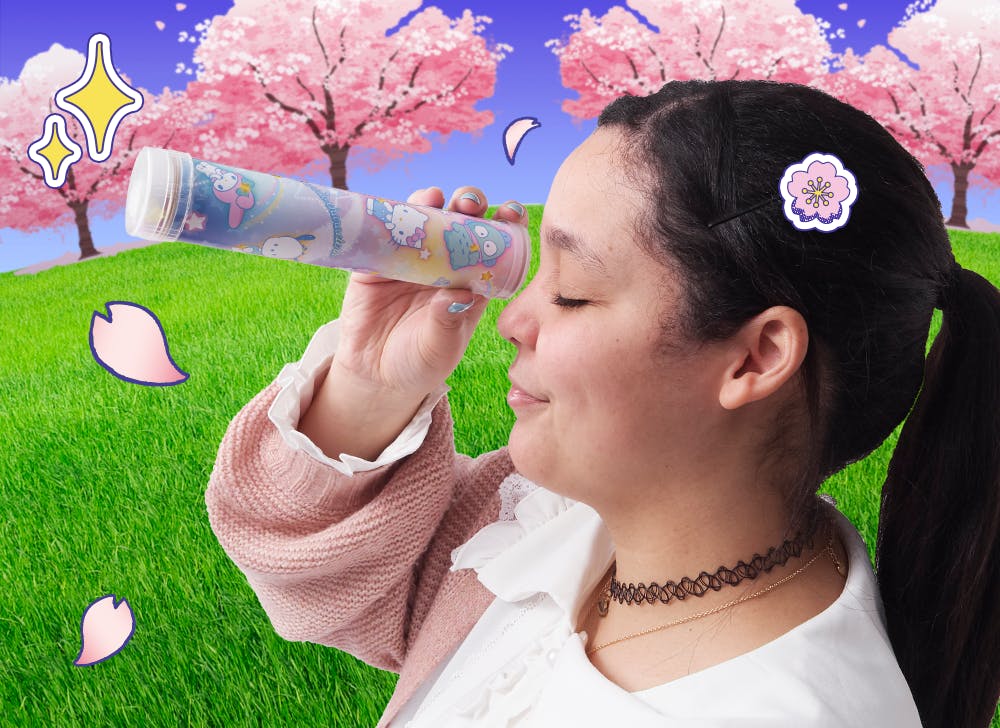 A picture of a woman looking through the DIY kaleidoscope in front of blooming cherry blossom trees
