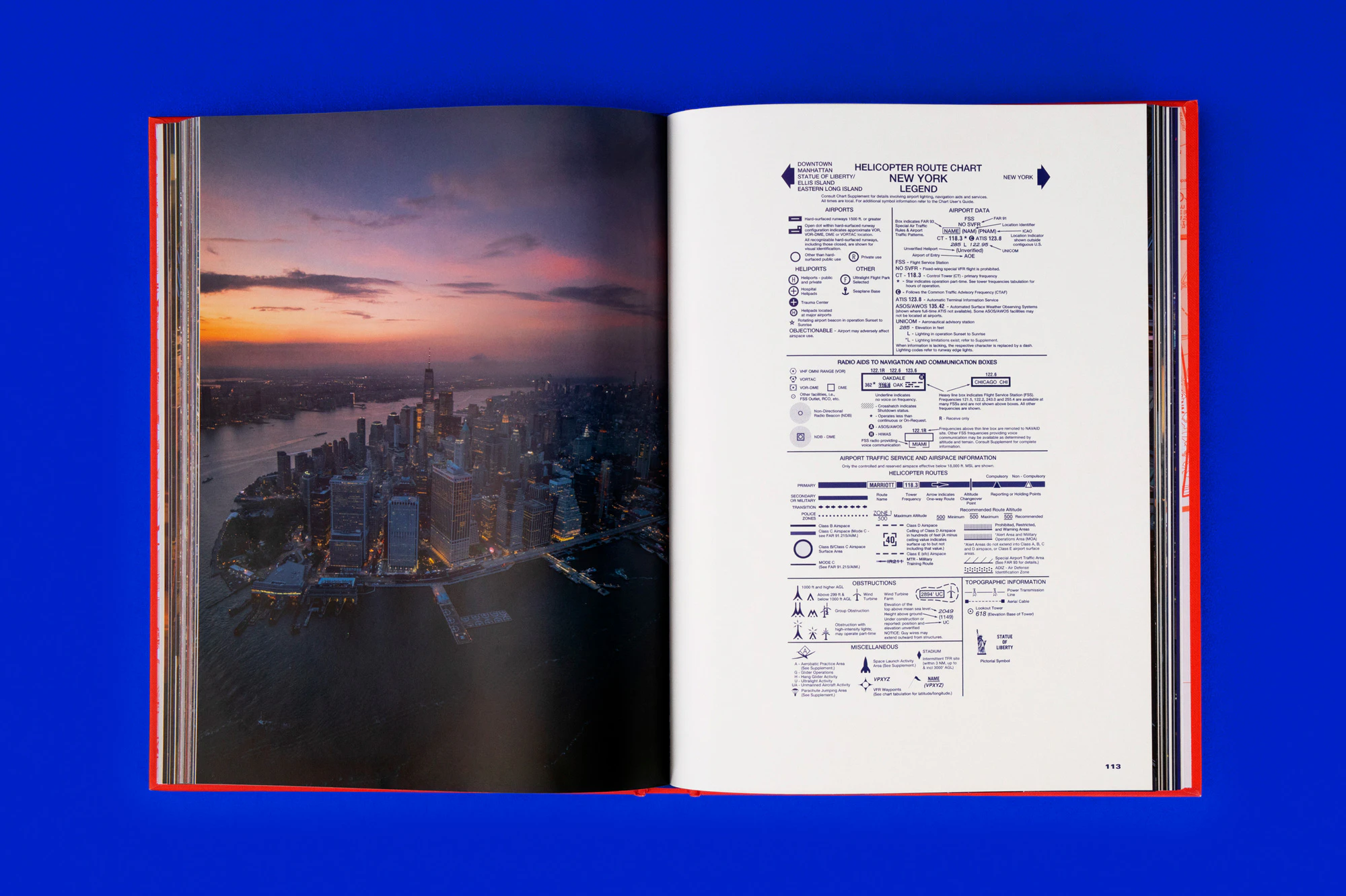 Overhead photo showing a spread from the book with a sunset NY skyline photo on the left and blue text on the right. The book is lying on a cobalt blue seamless.