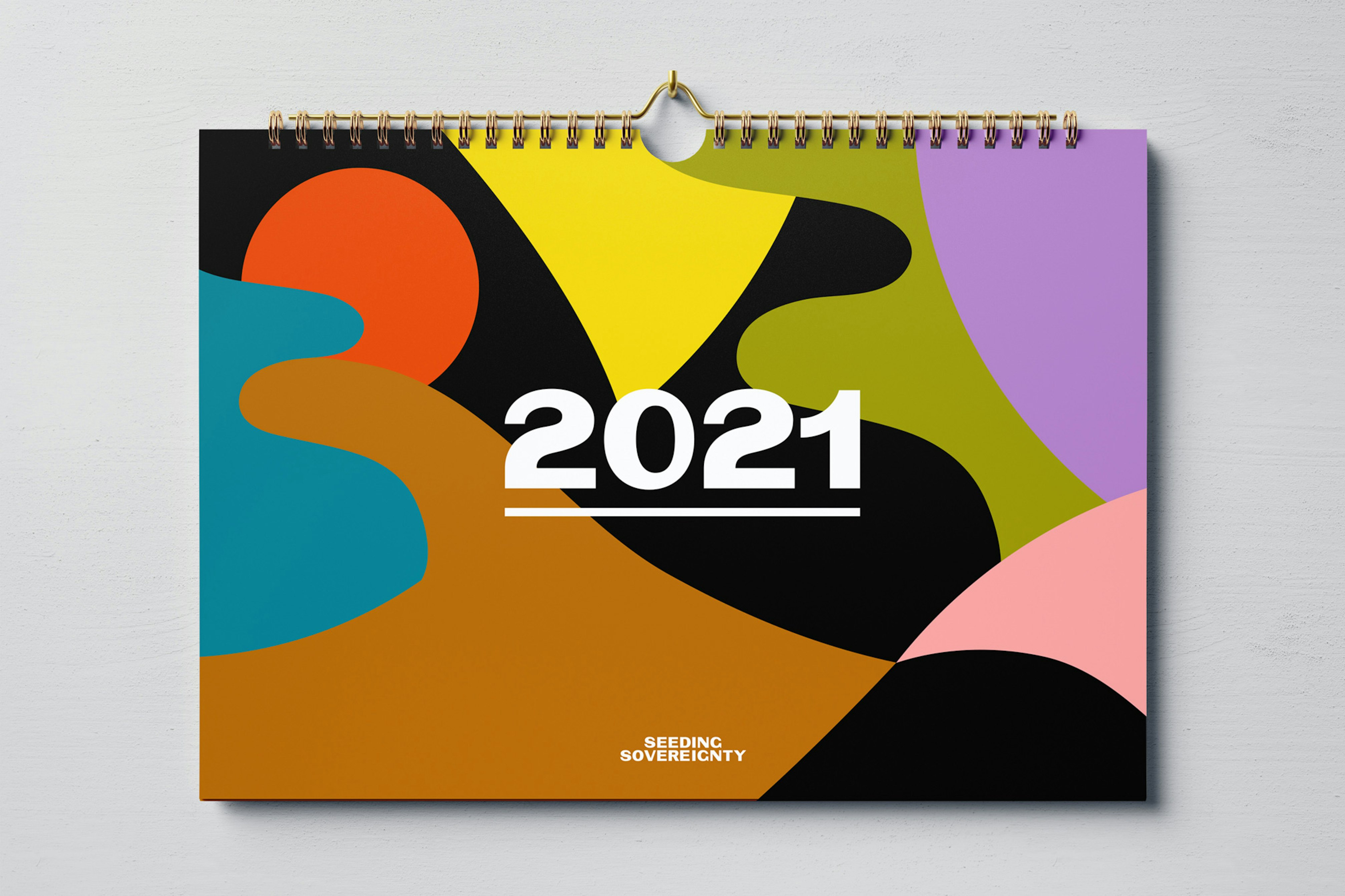 Image shows a calendar cover with multi-colored abstract shapes and the year 2021 on it in white text. 