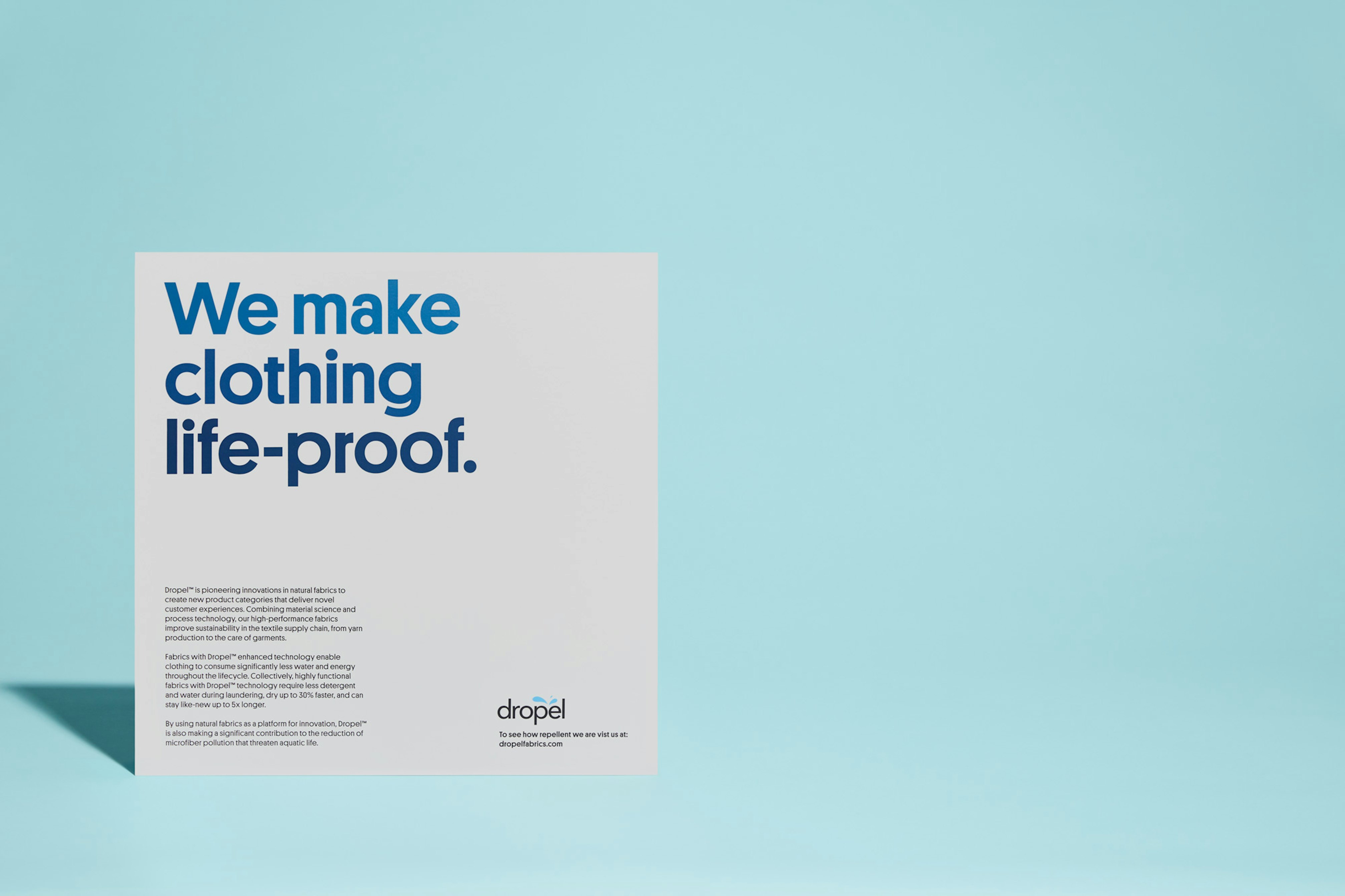 Image showing Dropel's tagline "we make clothing life-proof" typed in bold blue type on a light gray paper.