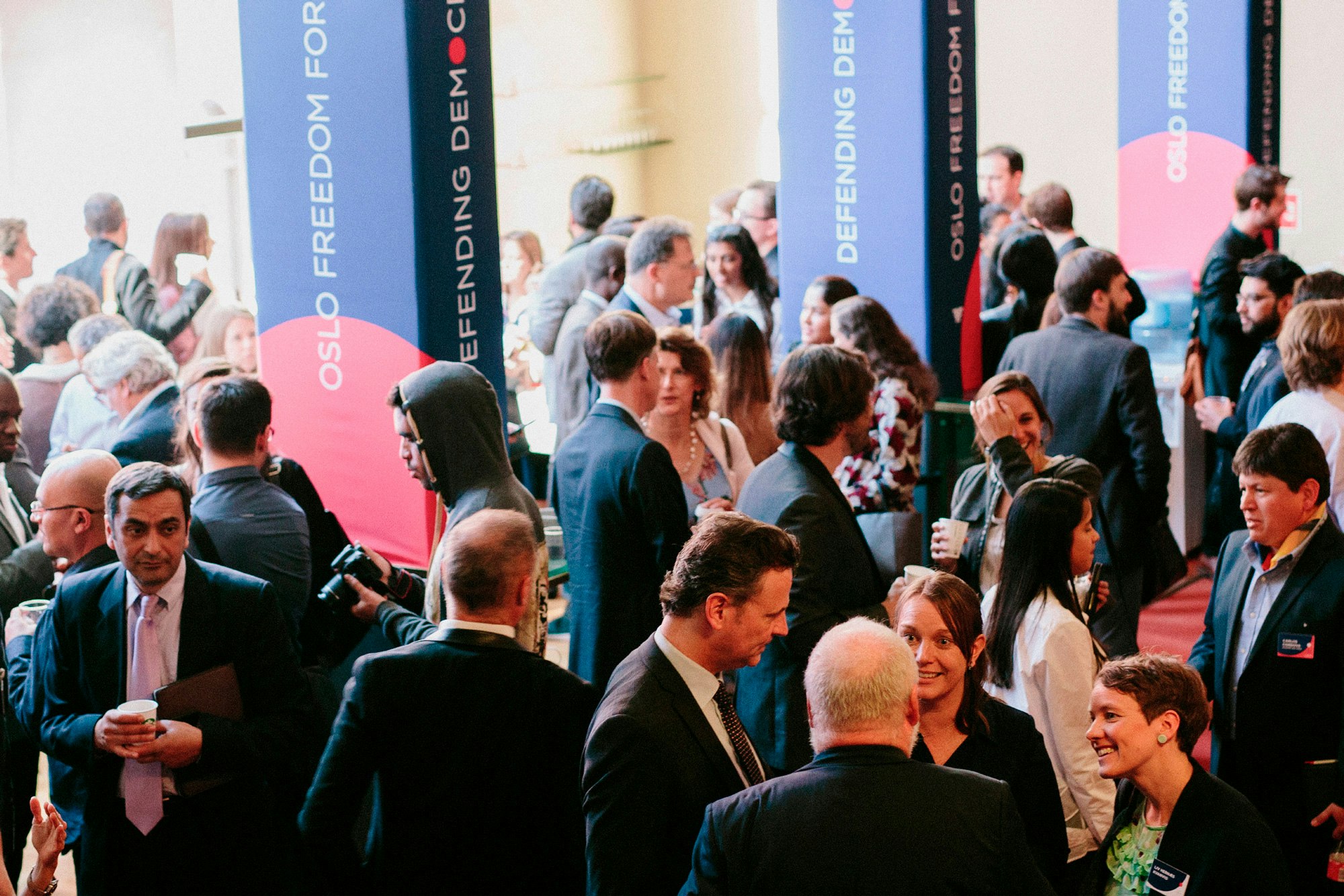 Image shows people gathered around OSLO FREEDOM FORUM column structures.