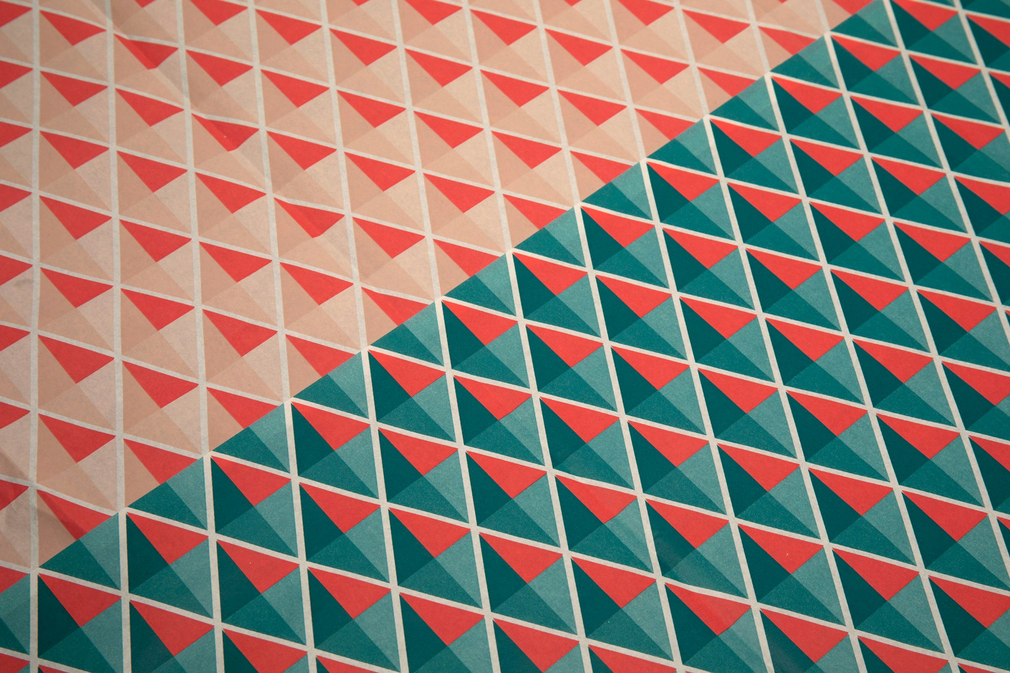 Image showing a close up crop of the tissue paper for the shoe boxes. It is a diamond pattern in beige, red, and teal colors.