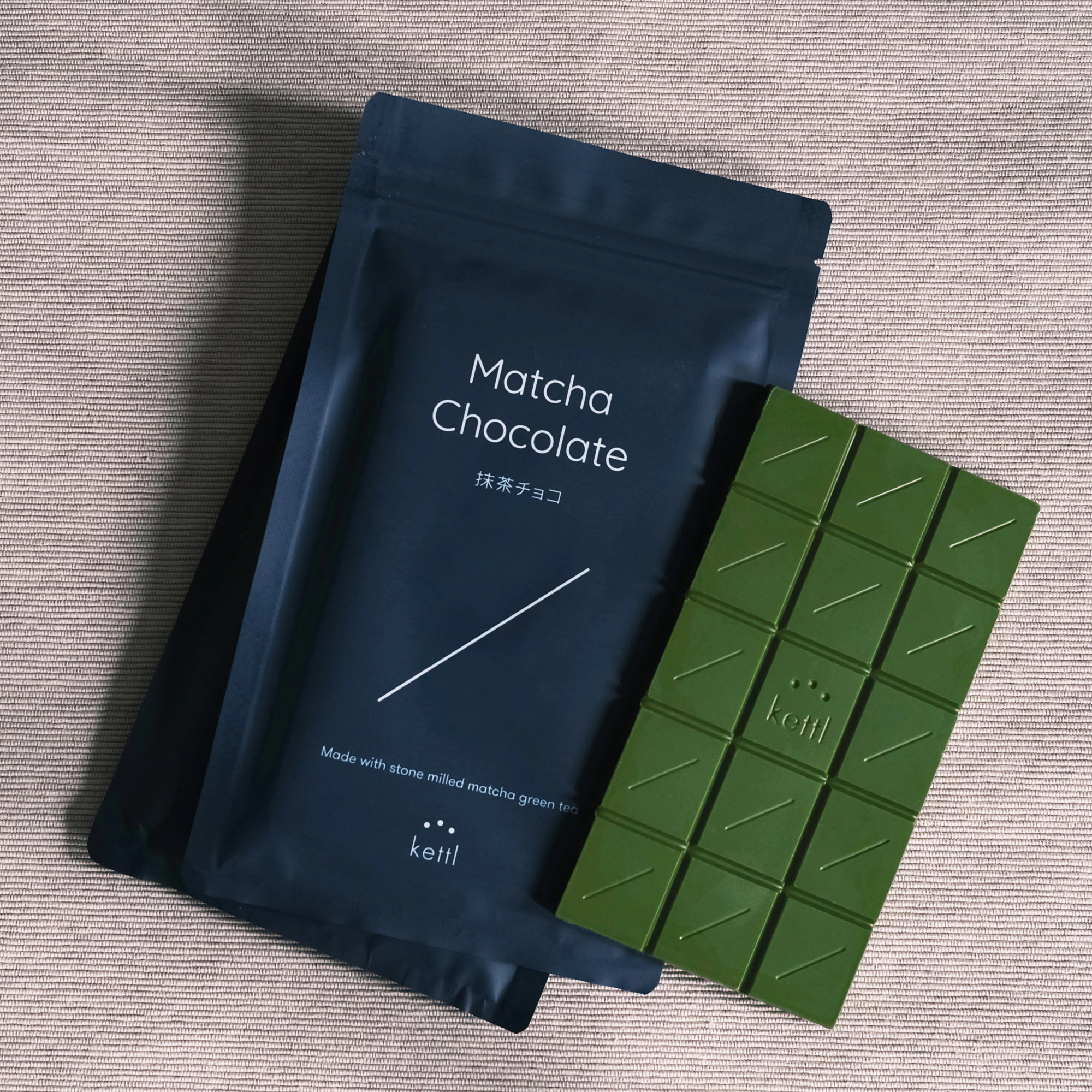 Image showing a pack of Kettl chocolate and the bar of chocolate next to the packaging. The chocolate is green from the matcha and the packaging is black with white writing on top.