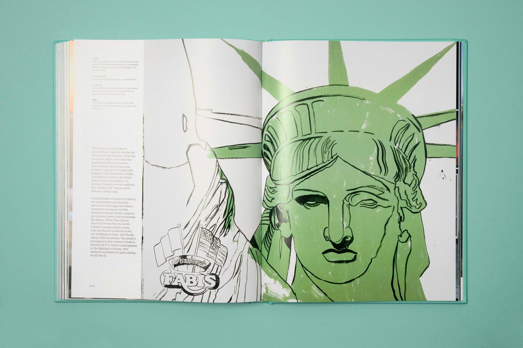 Image showing the book open showing a drawing of the statue of liberty. The book is lying on a green seamless.