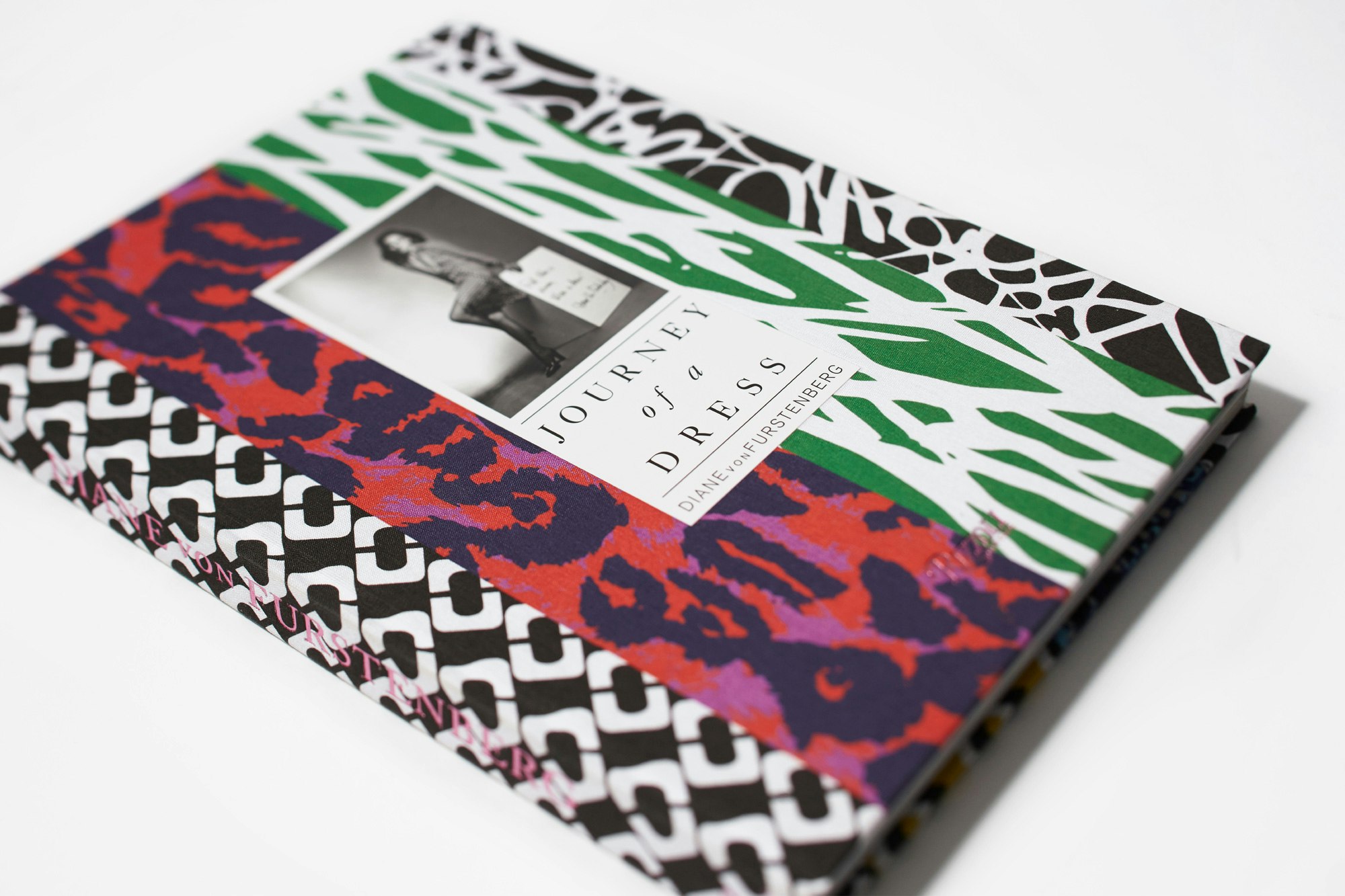 Image showing the Journey of a Dress book on a gray seamless. The book is covered in fabric showing the classic DVF prints.