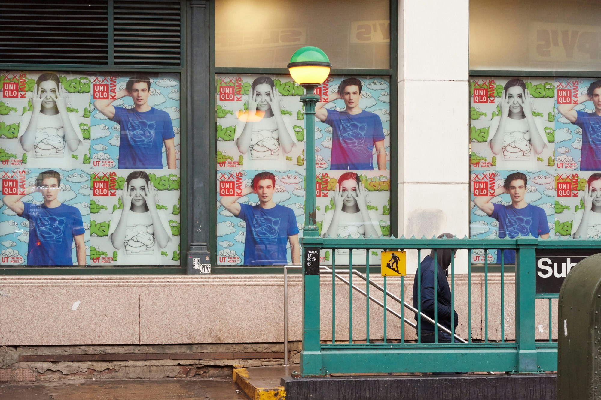 Image showing the outside of a NYC subway with the Uniqlo posters covering the background.