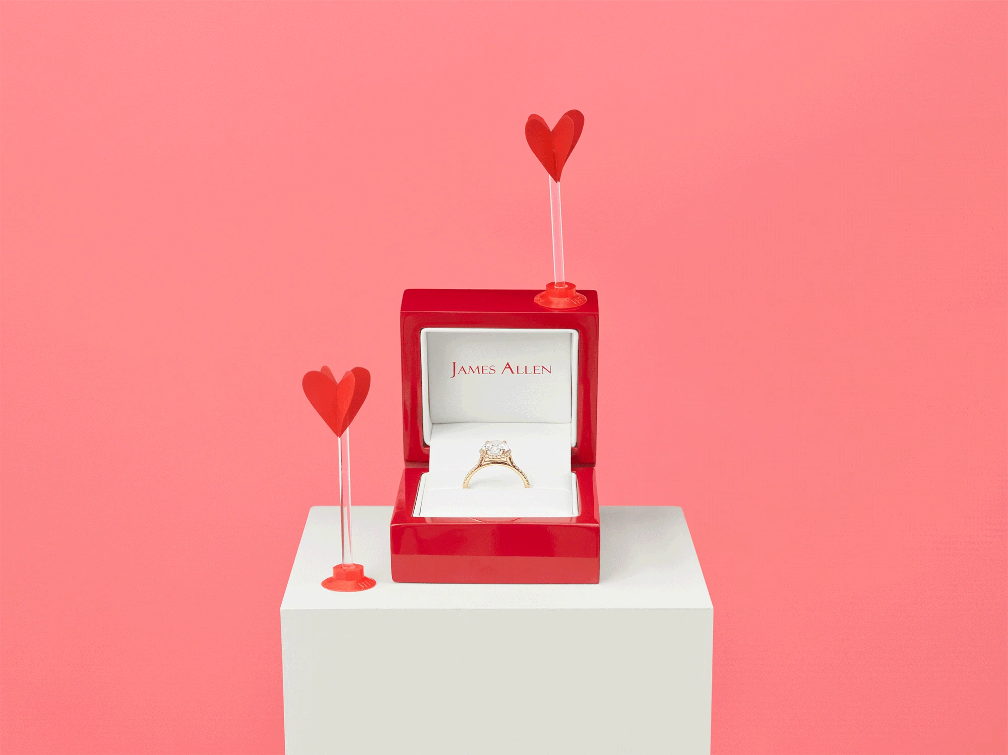Animation showing red mini heart arrows shooting towards an open ring box with an engagement ring inside.